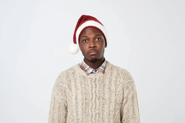Smutný a osamělý starší africký muž v Santa Claus klobouk nad bílým pozadím — Stock fotografie