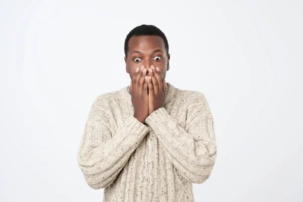 Потрясенный африканский мужчина закрывает рот руками — стоковое фото