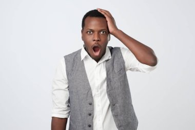 Beyaz gömlek ve şok ve hayal kırıklığı seyir yelek giymiş şaşkın veya sürpriz Afrika adam