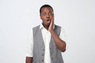 Beyaz gömlek ve şok ve hayal kırıklığı seyir yelek giymiş şaşkın veya sürpriz Afrika adam