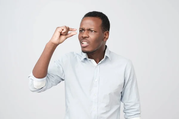 Handsome african man showing something little with hands while gesturing shocked — Stock Photo, Image