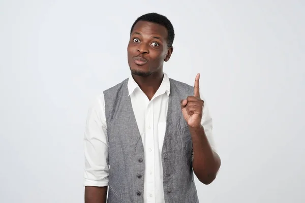 Молодой африканский человек поднимает указательный палец, чтобы понять, как сделать интересный проект . — стоковое фото