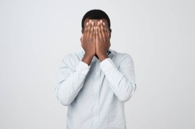 Afrika delikanlı yüzünü eli ile kaplı