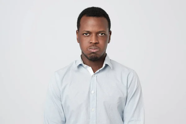 Africain soufflant des joues tout en étant offensé par quelqu'un montrant son émotion négative — Photo