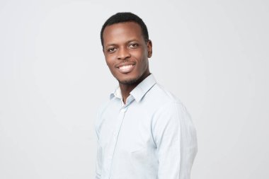 Beyaz bir arka plan üzerinde izole beyaz gömlekli yakışıklı bir siyah adam portresi. Olumlu yüz duygu
