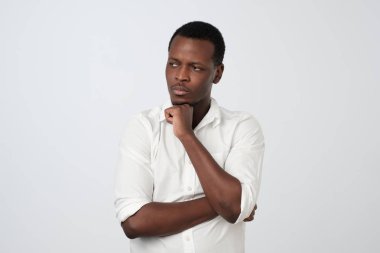 İnsan yüz ifadeleri, duygu ve duygu. Bir şey hatırlamaya çalışarak bir kenara düşünceli ve şüpheci bir ifadeyle, seyir Afro-Amerikan yakışıklı genç