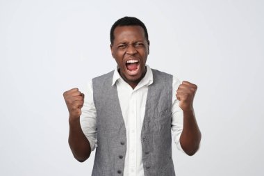 Çünkü o haber ile tahriş beyaz gömlek ve yelek genç Afrika adam bağırıyor.