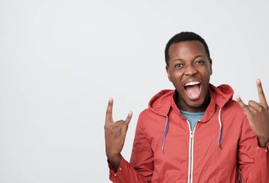 Çığlıklar ve bağırıyor, mutlu, büyük duygu kırmızı giysili genç Afrika adam. İmzala rock gösterilen.