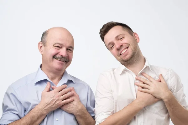 Far og sønn smilende glad, fornøyd med komplimenter eller gaver – stockfoto