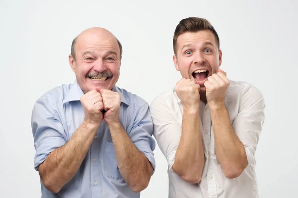 Retrato de dois homens surpresos pai e filho ou melhores amigos olhando para a câmera com a boca aberta — Fotografia de Stock