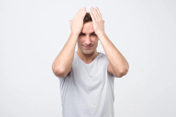 Засмучений нещасні італійський юнак стискаючи голова руками, страждають від головного болю. — стокове фото