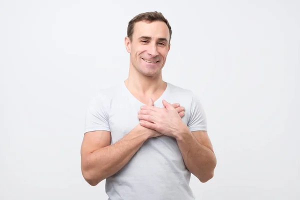 Vrolijke man lacht vrolijk, houdt handen op de borst, drukt zijn positieve emoties uit — Stockfoto