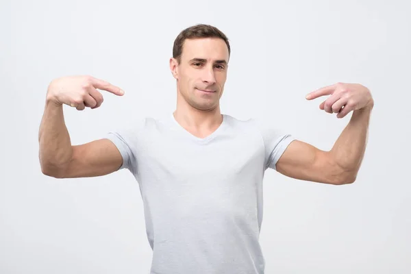 Italiaanse man in wit t-shirt, permanent, zichzelf te wijzen en op zoek met ernstige egoist gezicht. — Stockfoto