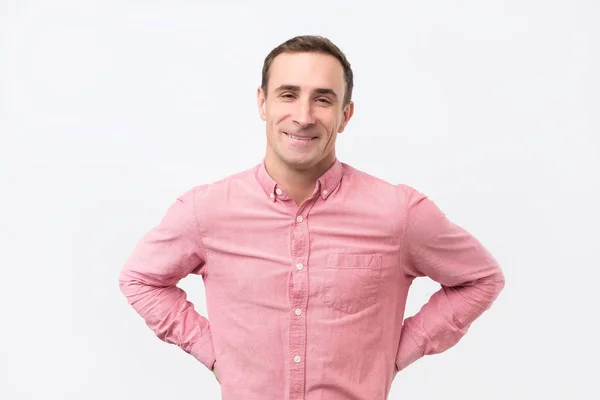 Bonito italiano homem vestindo camisa rosa com leve sorriso posando contra fundo branco — Fotografia de Stock