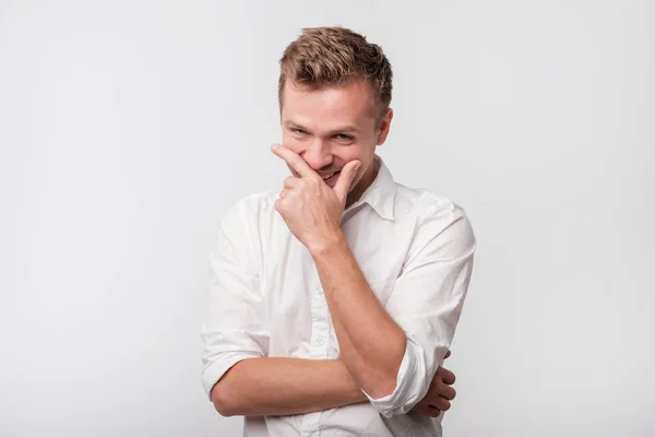 Volwassen man lachen en zijn mond met de hand die betrekking hebben op witte achtergrond. — Stockfoto