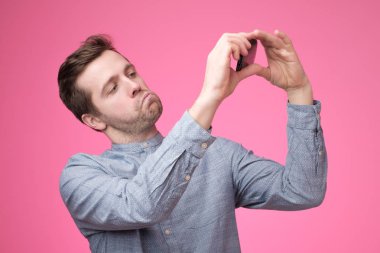 Selfie telefonunu alarak neşeli yakışıklı genç bir adam portresi