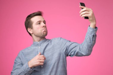 Selfie telefonunu alarak neşeli yakışıklı genç bir adam portresi