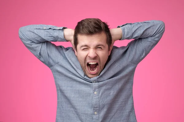 Young man covering his ears and shouting. — Stock Photo, Image