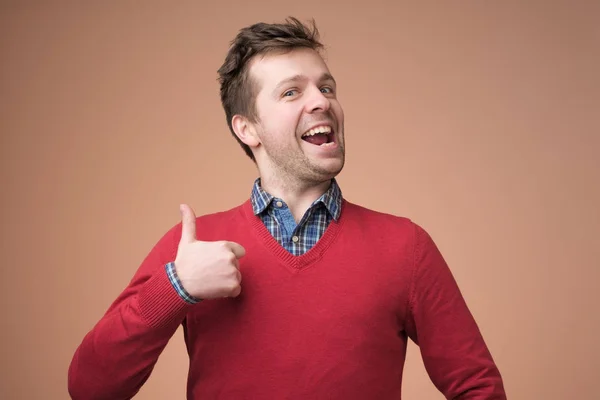 Szczęśliwy przystojny mężczyzna w czerwonym swetrze Wyświetlono kciuk w — Zdjęcie stockowe