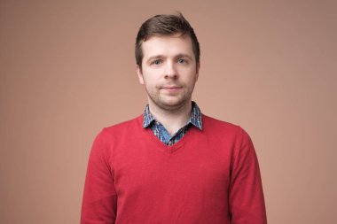 Çekici yakışıklı gülümseyen pozitif beyaz adam kırmızı kazaklı