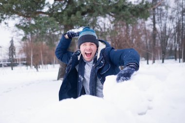 Sıcak giysiler açık kar ile oynarken Avrupa olgun adam. Kış tatil eğleniyor.