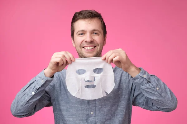 Joven Hombre Europeo Máscara Facial Sobre Fondo Rosa Aseo Mismo —  Fotos de Stock