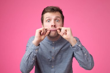 Portre romantik adam, büyük dudaklar gösteren. Dudaklarını büyütmek istiyor. Stüdyo çekimi.