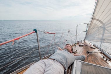 young european man resting on yacht looking at sky