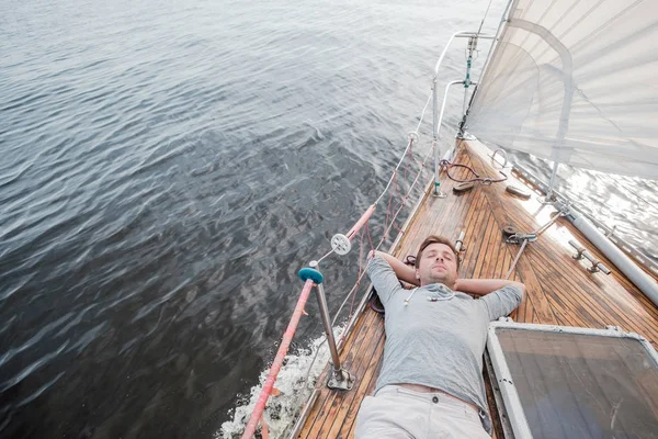 Joven europeo descansando en un yate mirando al cielo — Foto de Stock