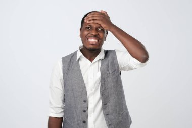 African man remembering funny men laughing out loud from joy and happiness holding hands on head