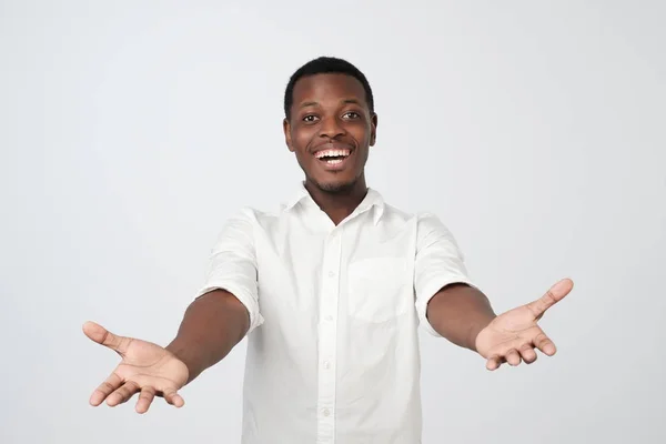 Povzbuzující Afričan v bílé košili, tahání ruce k kameře, chce se mazlit — Stock fotografie