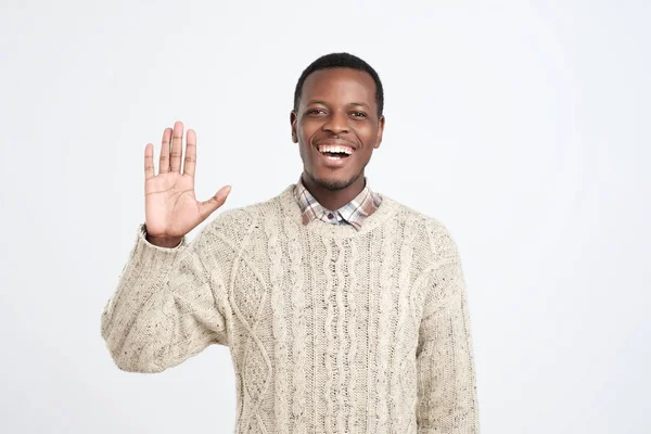 Zdvořilý mladý Afričan americký muž oblečený do svetru, který říká Ahoj — Stock fotografie