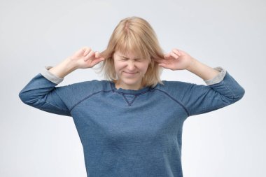 Kulaklar tıkalı, ararken, ne söyledi duymak gibi davranarak genç Avrupa kadın