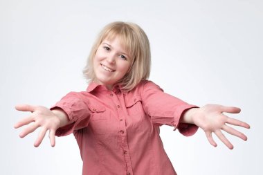 Avrupa kadın gergin eller ile pembe gömlekli. O arkadaşları sarılmak istiyor.