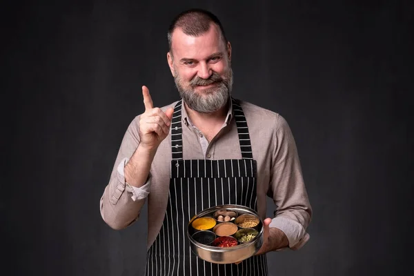 Chef barbudo que muestra diferentes especias que utiliza. Secreto de la deliciosa comida . —  Fotos de Stock