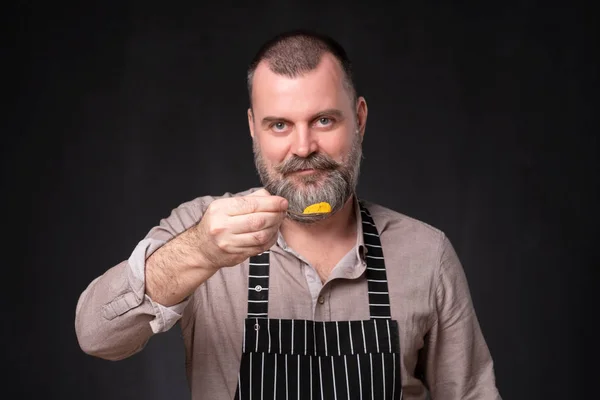 Europeam maduro chef mostrando su especia favorita, cúrcuma naranja —  Fotos de Stock