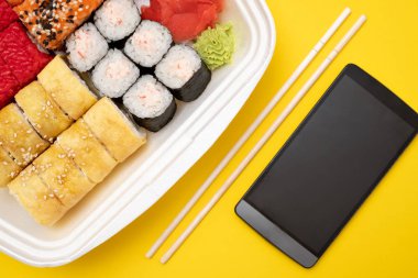 Üstten Görünüm suşi ayarla renkli arka plan üzerinde. Plaka rulo, zencefil ve vasabi ile