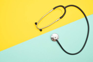Tıbbi phonendoscope veya sarı ve mavi arka plan ile boşaltmak izole stetoskop.
