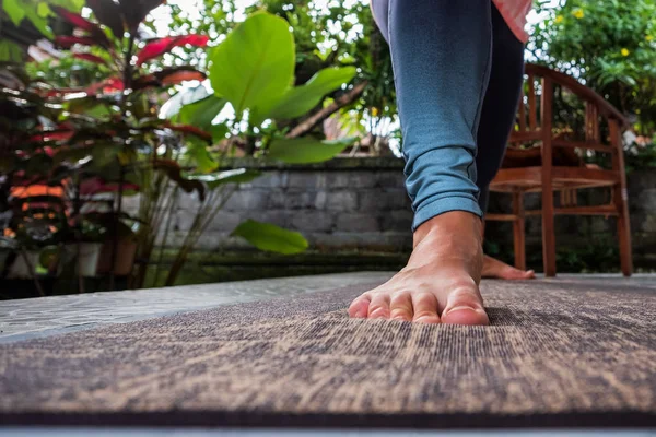 Frau streckt barfuß Bein in Sportbekleidung, blaue Yogahose zum Üben von Yoga — Stockfoto
