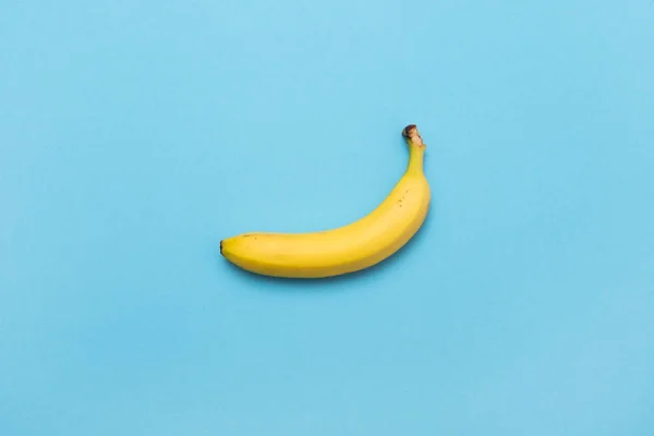 Plátano amarillo sobre fondo azul pastel. Moda mínima, flatlay . — Foto de Stock