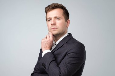 Kameraya bakarak takım elbiseli gülümseyen kendine güvenen adam