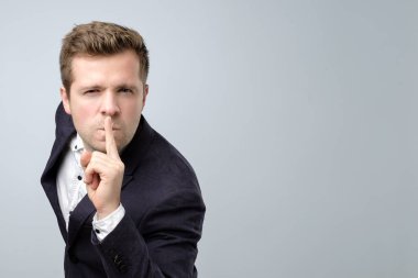 Sessizlik jest yapma takım elbiseli yakışıklı adam