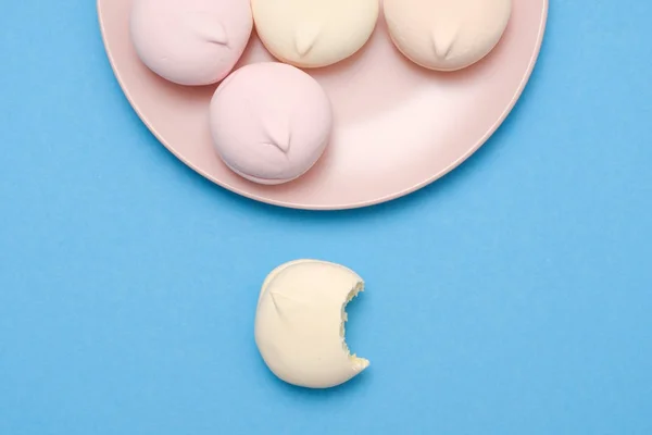 Gustosi e dolci marshmallow cerchio su piatto su sfondo blu con copyspace . — Foto Stock