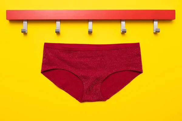 Pantalones de mujer en percha roja aislados sobre fondo amarillo — Foto de Stock