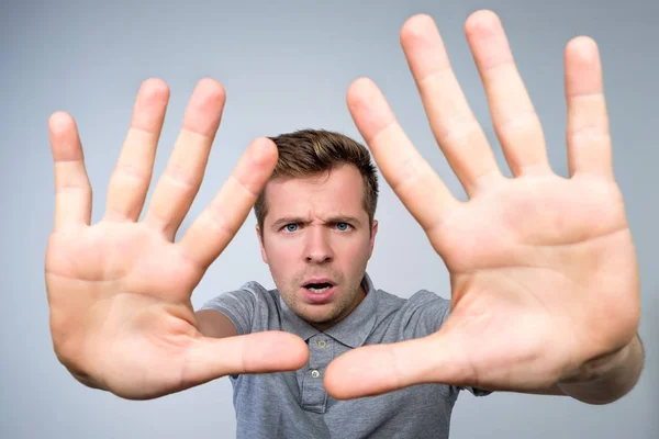 Young european man in gray t-shirt showing with hand stop timeout gesture. — Stock Photo, Image