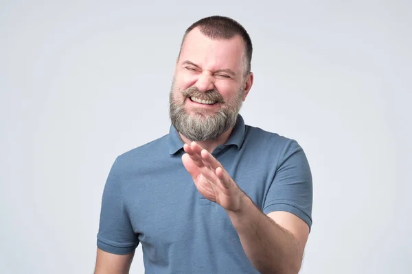 Laughing positive mature guy dressed in blue t-shirt showing stop gesture — Stock Photo, Image