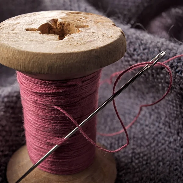 Швейная иголка и хлопковая нить на деревянной катушке . — стоковое фото