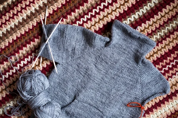 Neúplné, pletení šedý svetr pro dítě s jehlami — Stock fotografie