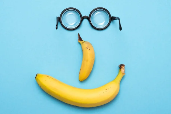 Κίτρινη μπανάνα και αστεία κύκλο glaases σε από του γέλια χαρούμενος πρόσωπό — Φωτογραφία Αρχείου