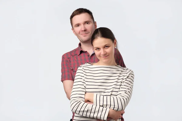 Jovem casal europeu em pé contra fundo cinza branco — Fotografia de Stock